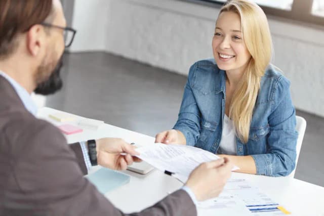Klant overhandigt een document aan onze adviseur
