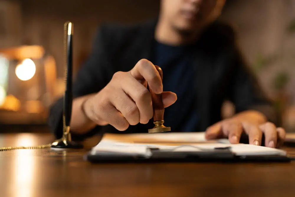 Vakreviewer in ons kantoor zet de stempel onder een afgeronde beëdigde vertaling